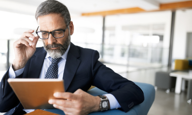 Investor of alternative investments looking at an ipad in an office